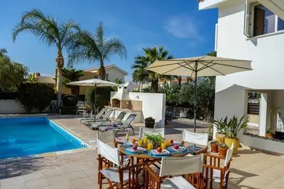 a patio with a table and chairs and a pool at Larnaca Villa Anthea 12 in Larnaka
