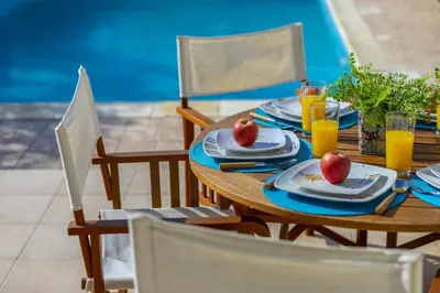 a wooden table with plates of food and orange juice at Larnaca Villa Anthea 12 in Larnaka