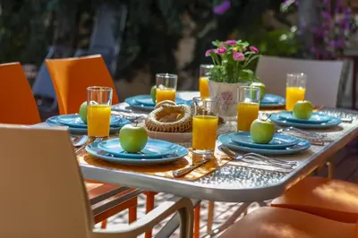 a table with blue plates and glasses of orange juice at Protaras Villa Rocco in Paralimni