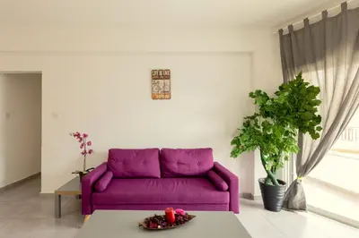 a purple couch in a living room with a table at Savvas City Centre Flat in Larnaka