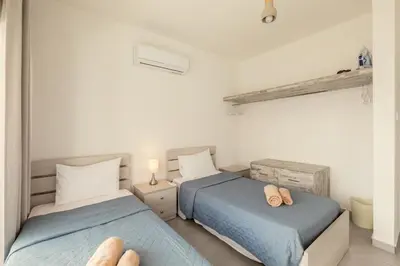 a bedroom with two beds and a mirror at Savvas City Centre Flat in Larnaka