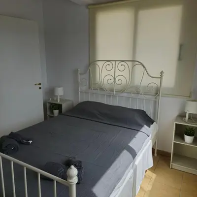 a bedroom with a large bed with a gray blanket at Merab Holidays Apartments FA213 in Ayia Napa