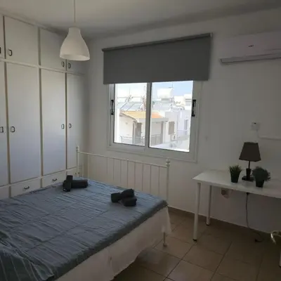 a bedroom with a bed and a window and a table at Merab Holidays Apartments FA213 in Ayia Napa