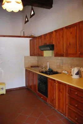 a kitchen with wooden cabinets and a stove top oven at Xenis House in Galata