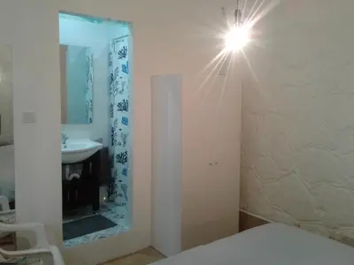 a bathroom with a sink and a light on the wall at Sparrows Nest in Larnaka