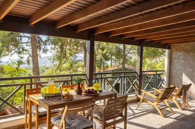 a patio with a table and chairs on a balcony at Platres Forest View Cottage in Platres