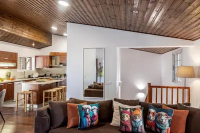 a living room with a couch and a kitchen at Platres Forest View Cottage in Platres