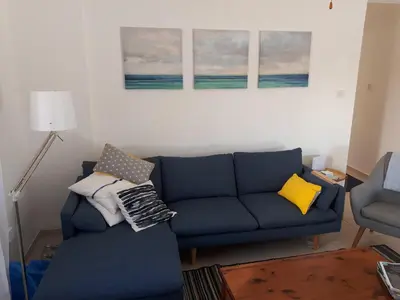 a living room with a blue couch and pillows at Villa Bouboulina Cyprus in Ayia Napa