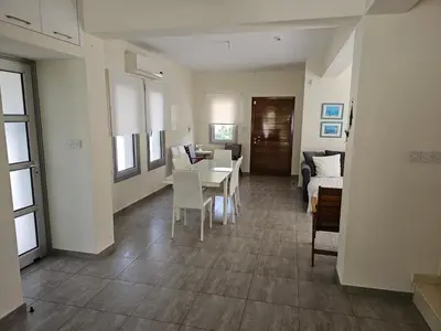 a living room with a table and chairs and a couch at FAMILY HOME in Protaras