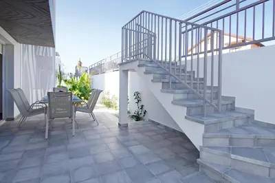 a patio with a staircase and a table and chairs at Villa Eden in Ayia Napa