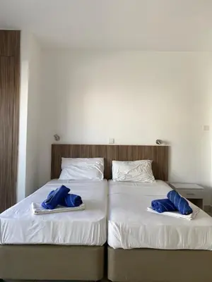 two beds with blue towels on top of them at Midtown Napa Apartments in Ayia Napa