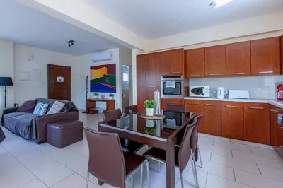 a kitchen and living room with a table and a couch at Villa Nova in Protaras