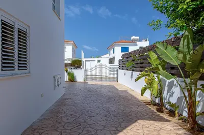 a pathway leading to a white building with a gate at Villa Nova in Protaras