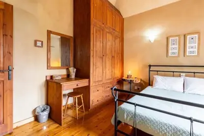 a bedroom with a bed and a desk with a mirror at Kardama HideAway in Kato Amiandos