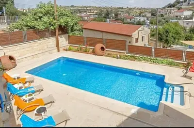 a swimming pool with chairs next to a building at Villa Elizabeth in Limassol