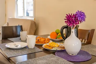 a table with plates of food and a vase with flowers at Villa Oceania in Ayia Napa
