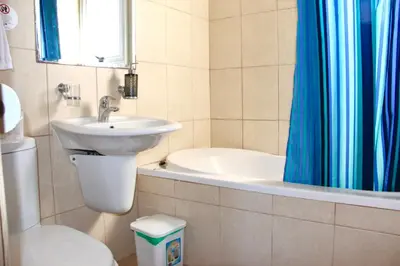 a bathroom with a sink and a toilet and a tub at Villa Oceania in Ayia Napa