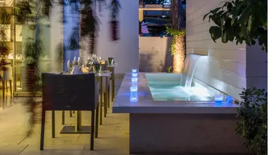 a restaurant with a table and a swimming pool at Alasia Boutique Hotel in Limassol