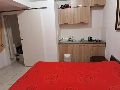 a kitchen with a red bed with a red blanket at City Large Studio in Limassol