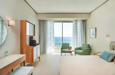 a hotel room with a bed and a view of the ocean at Sunrise Jade - Adults Only in Protaras