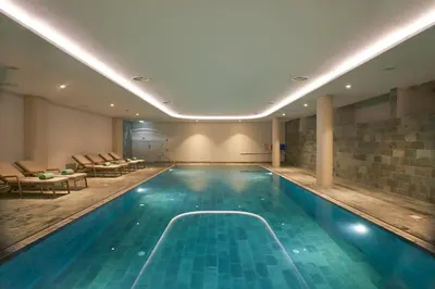 a swimming pool in a hotel with chairs and tables at Sunrise Jade - Adults Only in Protaras