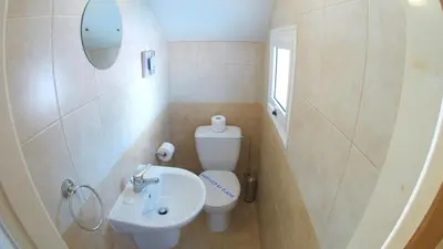 a small bathroom with a toilet and a sink at Villa Sunrise in Paralimni