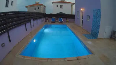 a large blue swimming pool in a building at Villa Sunrise in Paralimni