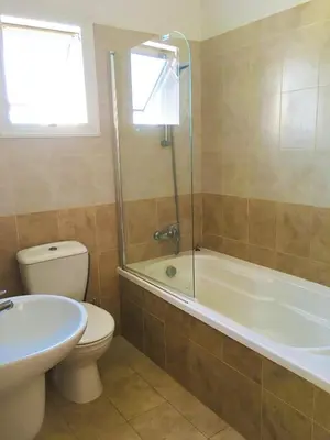 a bathroom with a toilet and a tub and a sink at Villa Sunrise in Paralimni