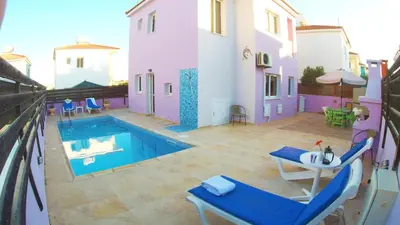 a balcony with a pool and a table and chairs at Villa Sunrise in Paralimni