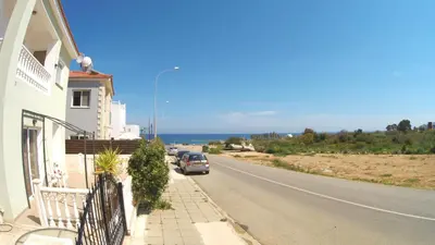 a car parked on the side of a road near the ocean at Villa Sunrise in Paralimni