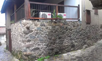 a stone wall with a balcony on a building at Patriko Traditional House in Kakopetria