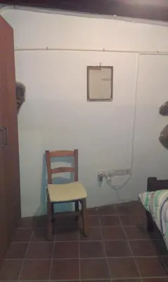 a chair sitting in a room with a mirror at Patriko Traditional House in Kakopetria