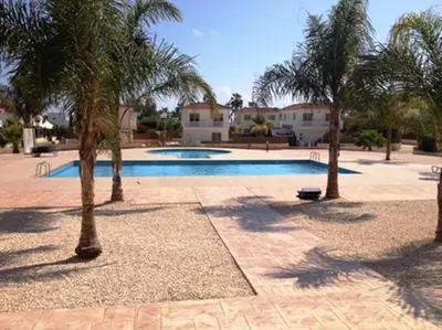 a swimming pool with palm trees around it at Nissi Sandy Bay C09 in Ayia Napa