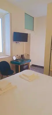 a room with a bed and a desk with a computer at Limassol Old Town Mansion in Limassol
