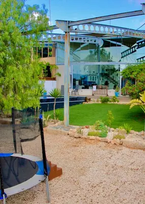 a swing in front of a large building at VILLA CATALEYA Fig Tree Bay Protaras Town Center in Protaras