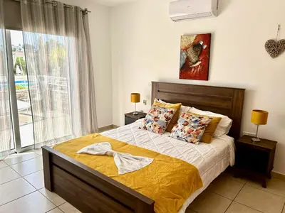 a bedroom with a bed and a large window at Nissi 3 C4 Pool View Apt in Ayia Napa