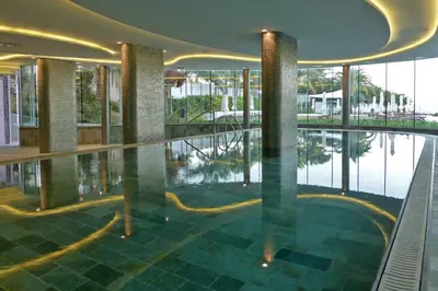 a swimming pool in a building with a reflection in the water at Sunrise Pearl Hotel & Spa in Protaras