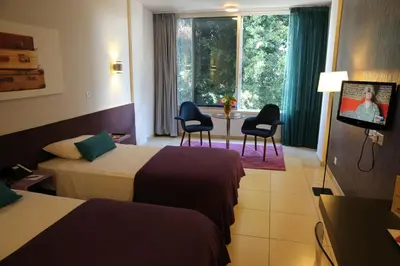 a hotel room with two beds and a table and chairs at Altius Boutique Hotel in Nicosia