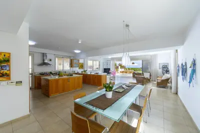 a kitchen and living room with a table and chairs at Protaras Beachfront Villa Pietra in Protaras