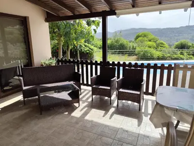 a patio with chairs and a table and a fence at Roses Villa in Trimiklini