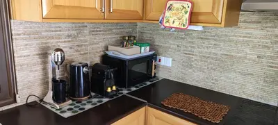 a kitchen counter with a coffee maker on a counter top at Roses Villa in Trimiklini
