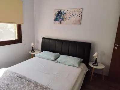a bedroom with a bed with white sheets and two lamps at Roses Villa in Trimiklini