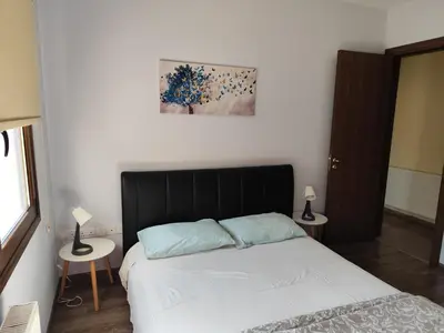 a bedroom with a bed and two tables with lamps at Roses Villa in Trimiklini