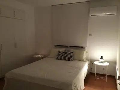 a bedroom with a white bed and two tables at RESIDENCE ONE in Limassol