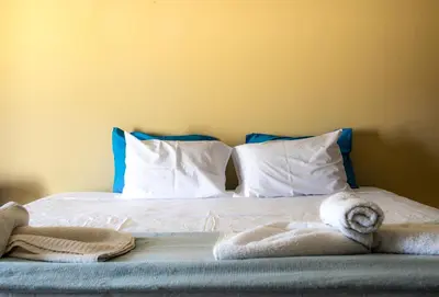 a bed with white sheets and towels on it at Lucky 2 in Paralimni