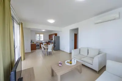 a living room with a couch and a table at Faros BeachFront Villa in Pervolia