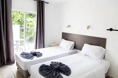 two beds in a room with a window at Summer's Hotel Apartments in Ayia Napa