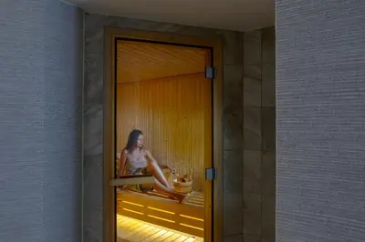 a woman sitting on a window sill in a room at Leonardo Crystal Cove Hotel & Spa – Adults only in Protaras