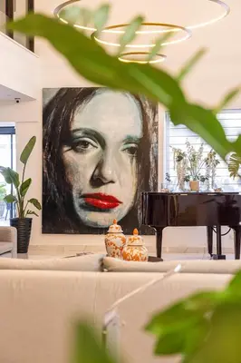 a painting of a woman on a wall next to a piano at Leonardo Crystal Cove Hotel & Spa – Adults only in Protaras