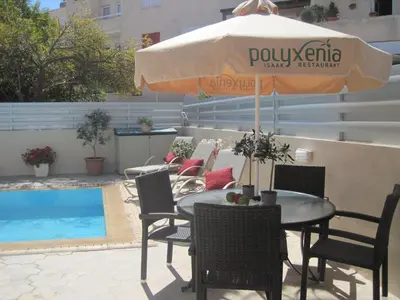 a table and chairs with an umbrella next to a pool at Polyxenia Isaak Luxury Villas and Apartments in Protaras